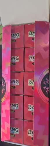 Colorful boxes with a pink and purple packaging design visible in stacked rows inside a display case