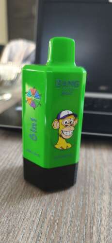 Bright green Gnili Bud Bang Ice e-liquid bottle with a cartoon monkey sticker, black base, and a small color wheel graphic on the side.