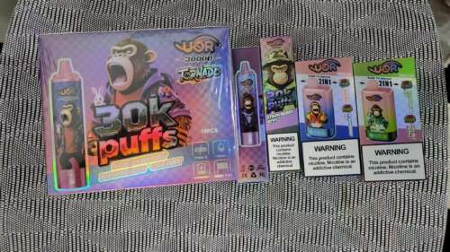 Kleurrijke verpakking voor een "30k puffs" vape-apparaatset met een aapkarakter, met een grote paarse doos en verschillende kleinere dozen/kaarten met smaken en waarschuwingen.